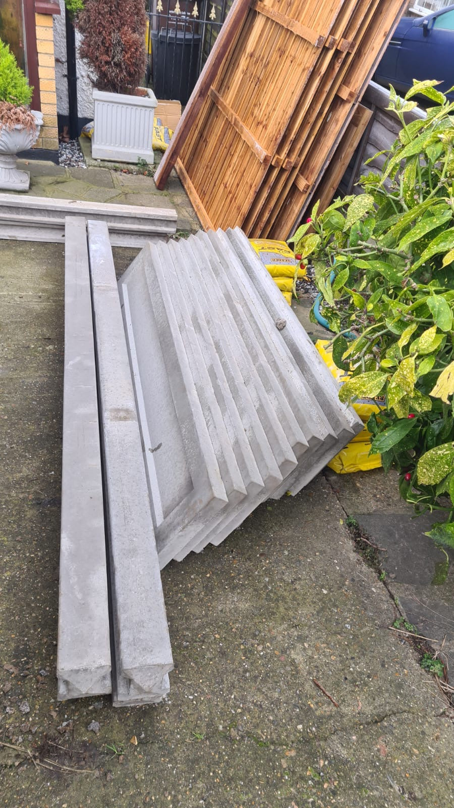 Stack of wooden panels, concrete posts and concrete gravel boards professionally delivered by Romford Fencing Ltd