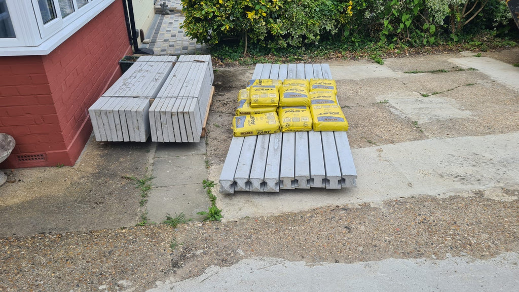 Stack of concrete posts, bags of postmix and concrete gravel boards professionally delivered by Romford Fencing Ltd