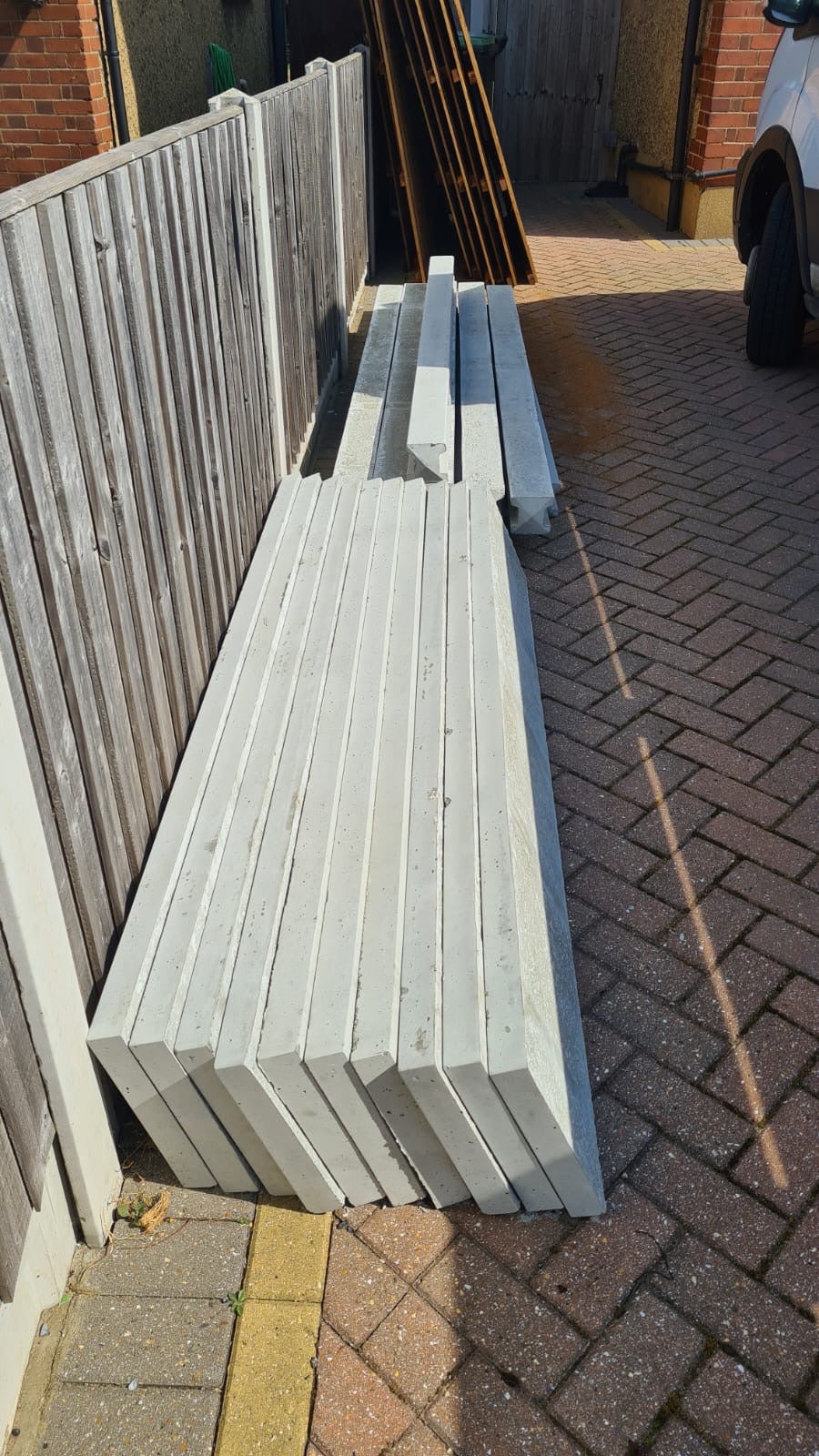 Stack of wooden panels, concrete posts and concrete gravel boards professionally delivered by Romford Fencing Ltd